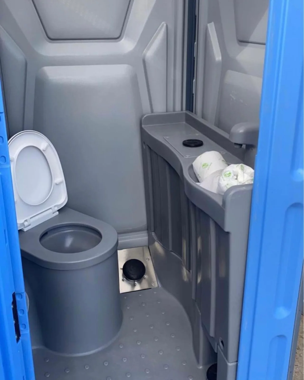 Portable toilet interior with a flushing bowl, sink and urinal
