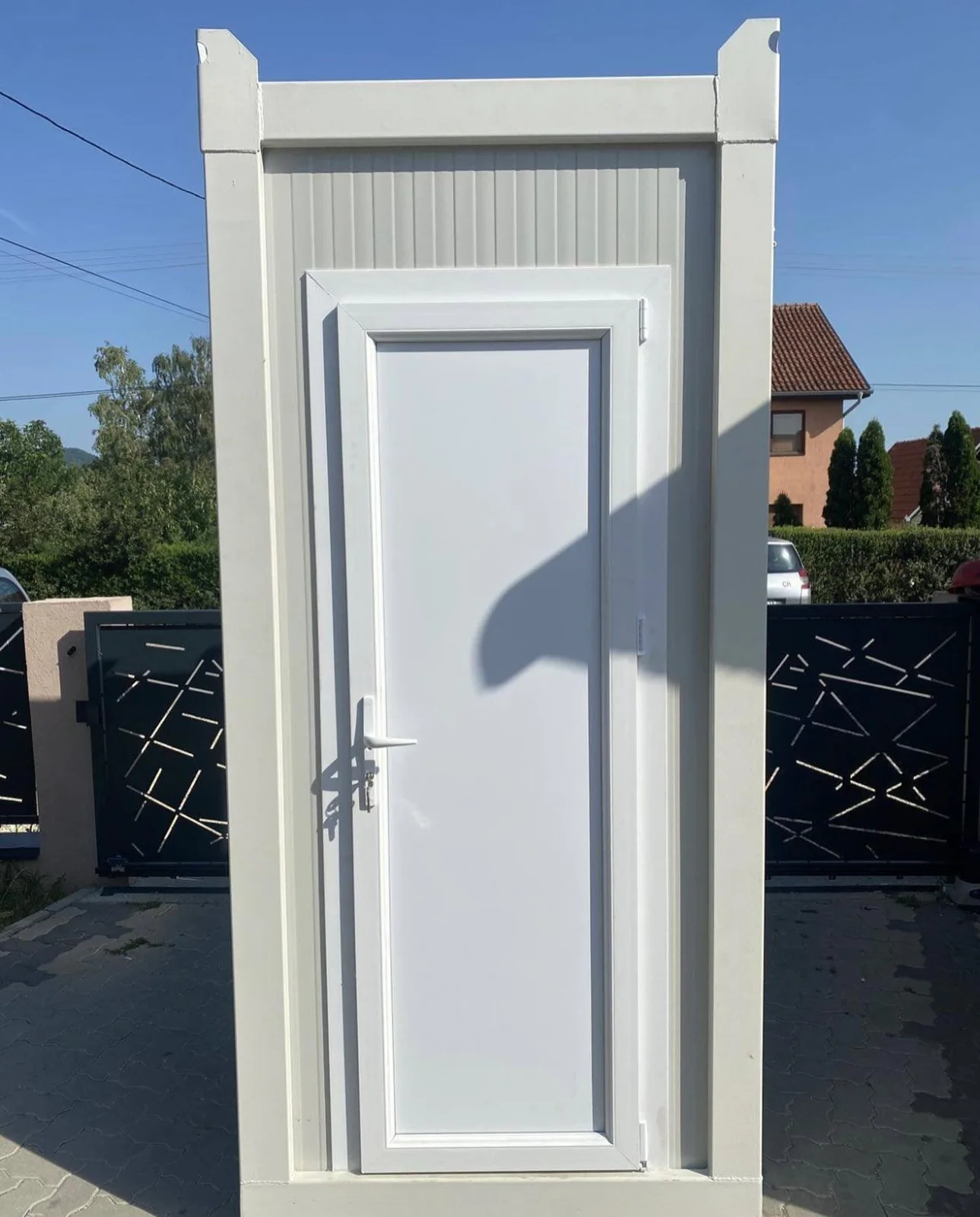Gray portable toilet beside a building