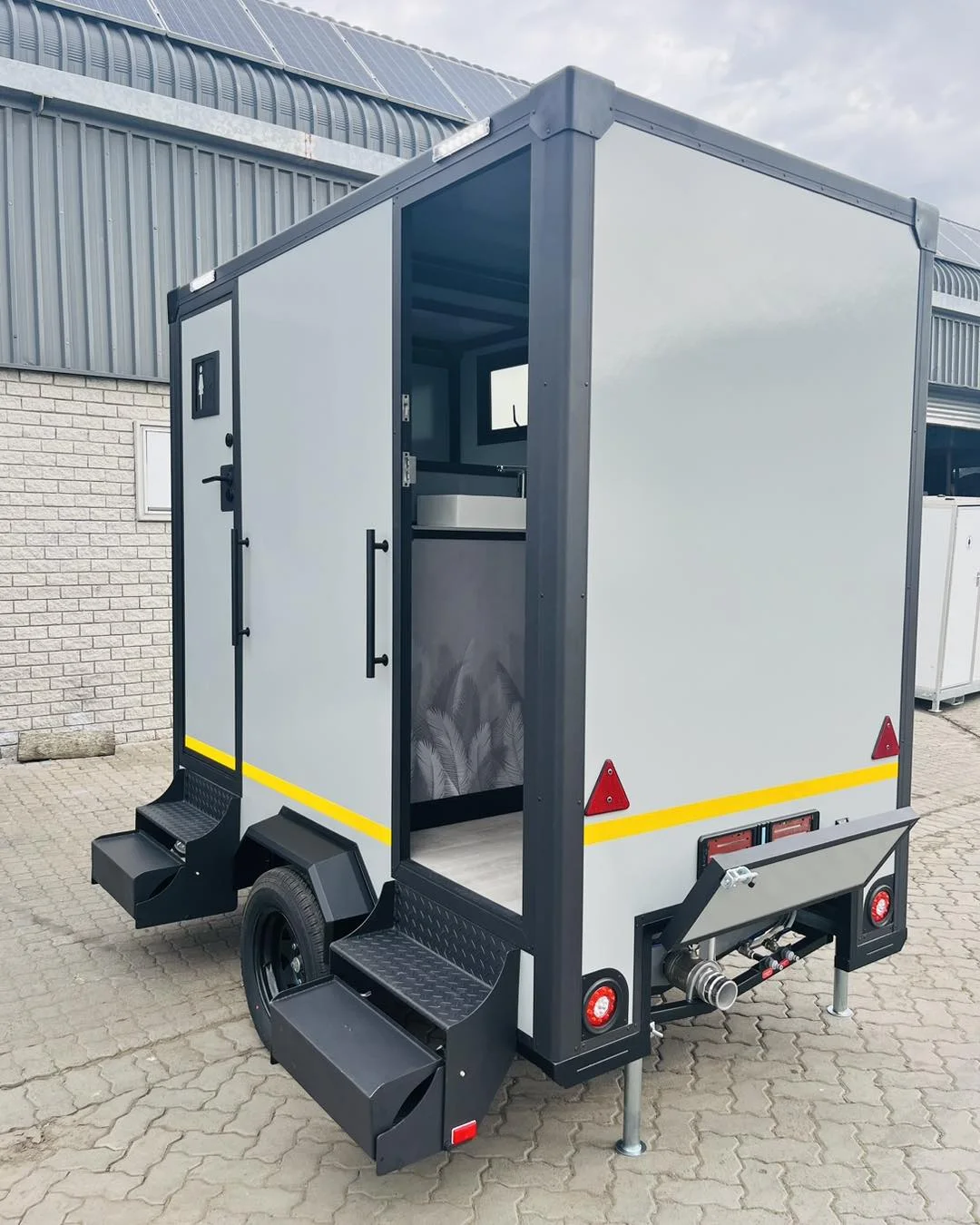 Two-door restroom trailer with exterior steps and an open entrance
